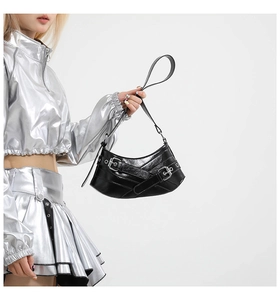 Detail of black glossy patent leather shoulder bag with punk silver buckles and straps