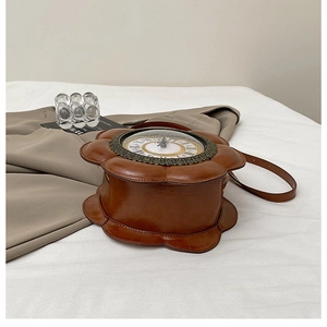 Macro detail of retro clock-face design on flower-shaped brown leather handbag