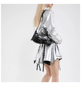 Detail of a black glossy leather Y2K shoulder bag with metallic buckles and punk hardware