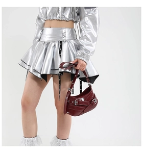 Detail of wine red crescent bag with metallic buckles paired with silver Y2K outfit
