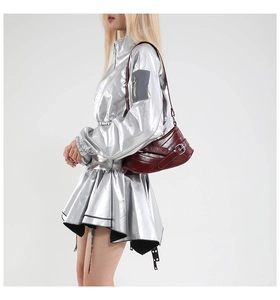 Close-up of a burgundy vintage underarm bag with silver buckle on metallic outfit