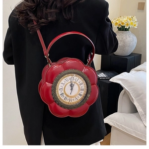 Detail of red flower-shaped handbag featuring a vintage clock face design and leather texture