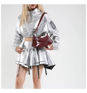 Detail of burgundy leather shoulder bag with vintage buckles and metallic finish