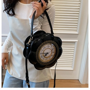 Detail of vintage black floral clock bag with Roman numerals and metal frame