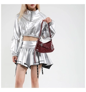 Close-up of a burgundy shoulder bag with multiple buckles and silver metallic jacket