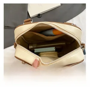 Detail view showing spacious interior compartments of the cream and brown shoulder bag