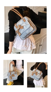 Detail of light blue denim underarm bag with brown leather trim and bow decoration