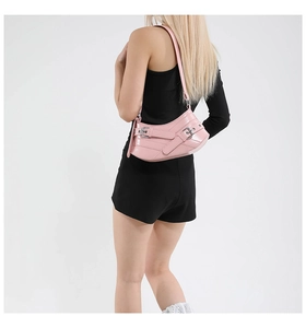 Detail view of pink Y2K style crescent shoulder bag with metallic buckle and eyelet straps