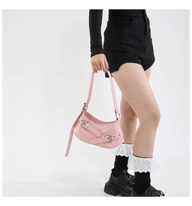 Detail of pink Y2K shoulder bag with silver buckles and polished finish on model