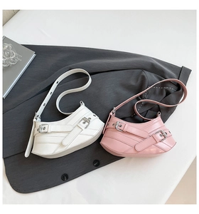 Flat lay of pink and white crescent shoulder bags with buckle detail and smooth PU finish