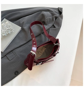 Top view of wine red shoulder bag with beige lining and silver metal eyelet strap detail