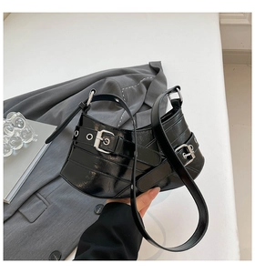 Detail of black glossy biker bag with silver buckles and adjustable leather straps
