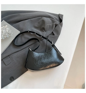 Detail of black glossy oil-wax leather shoulder bag with silver metallic hardware buckle