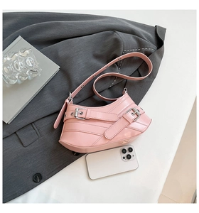 Detailed top view of pink glossy leather bag with decorative silver buckles and straps