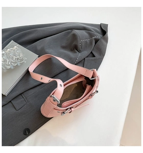 Detailed shot of pink leather hobo bag with silver metallic eyelets on grey blazer