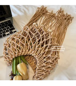 Detail of woven beige rope bag with white pearls and long bohemian fringe tassels