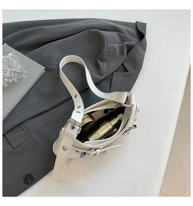 Top view of white faux leather shoulder bag showing interior space with phone and makeup