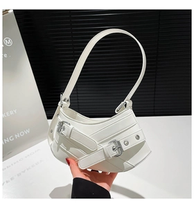Detail of white crescent shoulder bag with silver metal buckles and eyelet leather straps