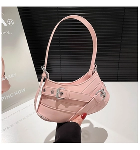 Detailed shot of pink Y2K motorcycle style underarm bag with silver buckle and eyelet details