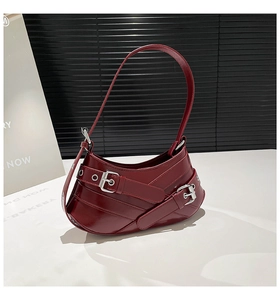 Detail view of burgundy semi-moon shoulder bag with silver buckles and glossy leather finish
