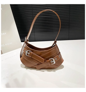 Close-up of brown PU leather shoulder bag with decorative straps and silver buckles
