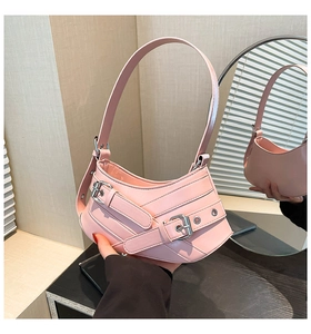 Detailed view of pink hobo bag with pebbled texture and silver buckle straps