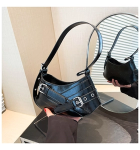 Detail of black crescent shoulder bag with glossy leather texture and silver buckle strap