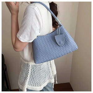 Close-up of sky blue woven texture and matching coin purse on an elegant shoulder bag
