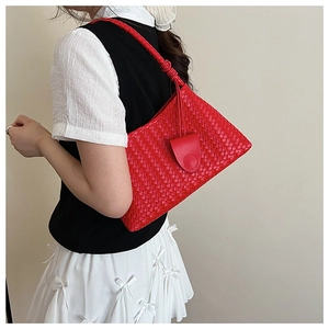 Detail of red hand-woven leather shoulder bag featuring intricate checkered texture