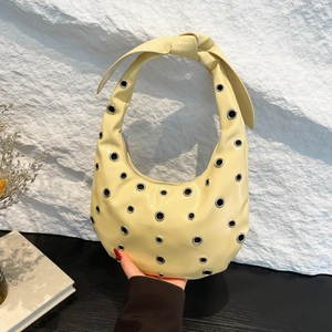 Creamy yellow crescent bag with silver rivet studs and stylish knotted strap design