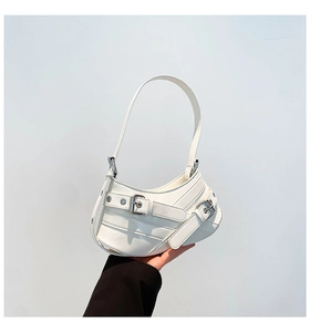 Detail of white half-moon shoulder bag with glossy faux leather and metal buckles