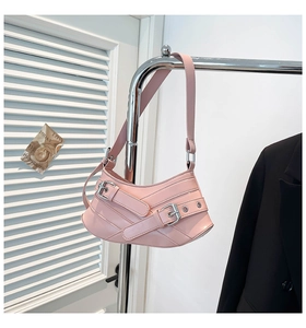Detail of pink crescent bag with silver metallic buckles and crisscross straps
