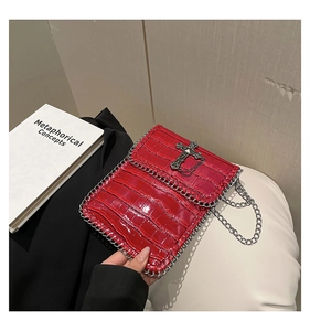 Détails de la texture crocodile rouge avec croix métallique et bandoulière à chaîne