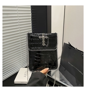 Détail du sac noir effet crocodile avec croix argentée et bandoulière en chaîne