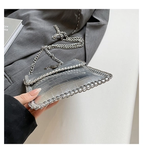 Détail du sac argenté texture crocodile avec bordures en chaîne et style punk chic