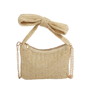 Beige straw woven crossbody bag with a large bow handle and gold chain strap