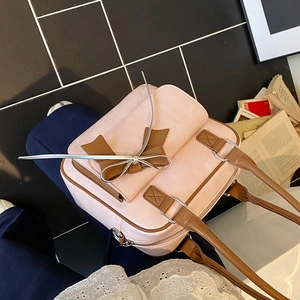 Pink leather shoulder bag with brown bow accent in a stylish 45-degree angled view