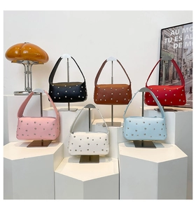 Detail of rivet-decorated crescent moon bags in six vibrant colors on display