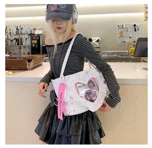 Detail of white ita bag featuring a large heart-shaped clear window and ruffle edges