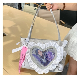 Close-up of heart-shaped window on silver ita bag with anime illustration and lace