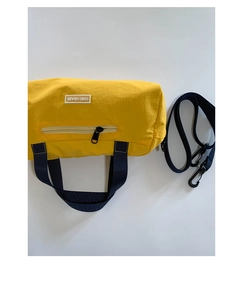 Dettaglio della borsa a cilindro in nylon giallo con etichetta chic e cinturini