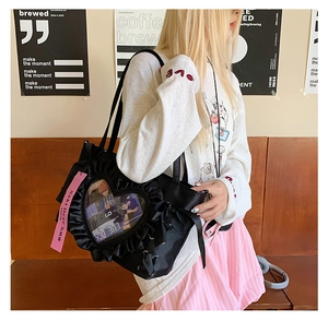 Detail of black ita bag featuring heart-shaped clear window and ruffle trim decoration