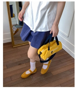 Detail of yellow nylon barrel tote bag and matching mary jane shoes for daily commute