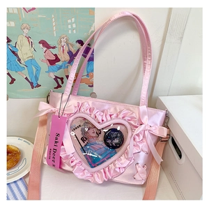 Detailed close-up of a pink satin ita bag with a heart-shaped ruffled clear window