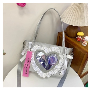Close-up of silver-grey itabag with heart window, lace ruffles and cute satin bow
