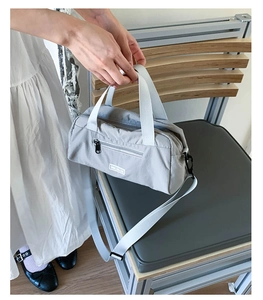 Dettaglio della borsa tote in nylon grigio con tasca con zip e logo CHIC CHAIZE bianco