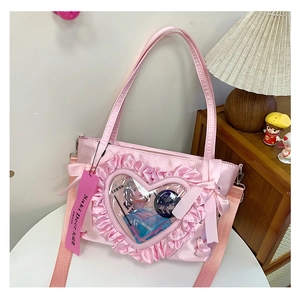 Detailed pink Ita bag featuring a heart-shaped clear window and ruffle edges with bows