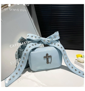 Vue détaillée du sac en cuir verni bleu clair avec croix en métal et nœud clouté