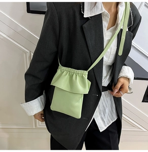 Détail du petit sac à bandoulière vert clair plissé avec cordon de serrage et cuir grainé