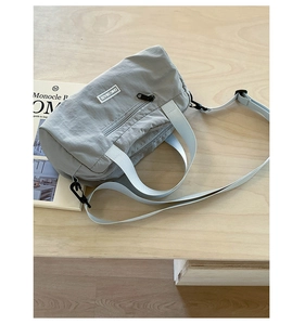 Dettaglio della borsa tote in nylon grigio-blu con tracolla bianca e logo Chic Craze